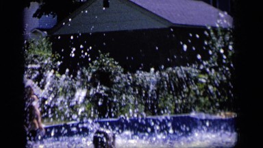 1964: a little girl splashes into an above ground pool in a backyard. CAMDEN