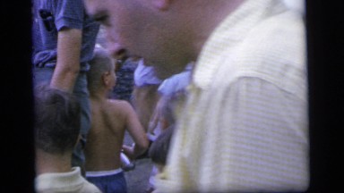 1964: dozens of people including children mengling around a pond