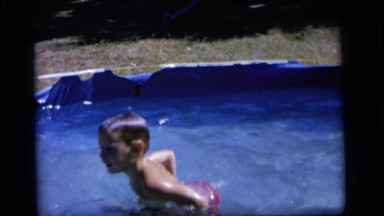 1964: two small boys swimming, diving and playing in a small pool