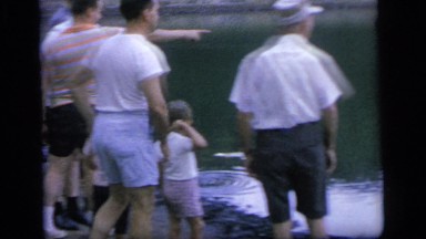 1964: people are standing on the shore of a lake with floating bags CAMDEN NEW