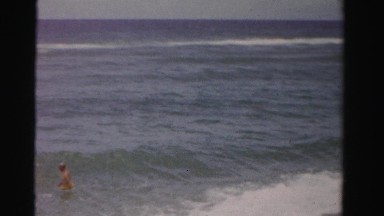 1955: working hard to keep their footing in the crashing waves of the ocean.