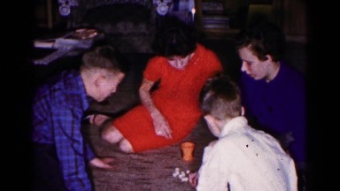 1961: family sitting on carpet playing games HAGERSTOWN, MARYLAND