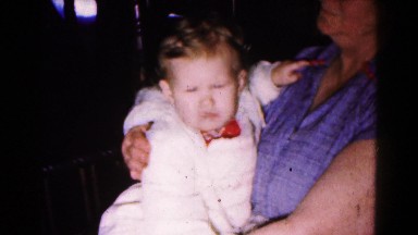 1961: proud grandmother holding baby in rocking chair HAGERSTOWN, MARYLAND