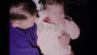 1961: child holding baby brother puts down cute boy smiles HAGERSTOWN, MARYLAND