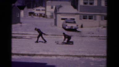 1961: friend pulling boy on sled across suburban winter snowscape HAGERSTOWN