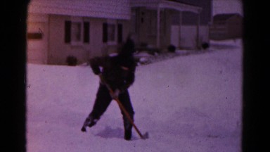 1961: shovelling snow and two kids throwing ball HAGERSTOWN, MARYLAND