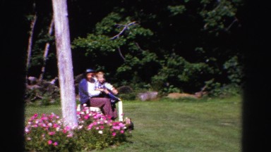 1958: father and his son are travelling in an electric scooter on the meadow