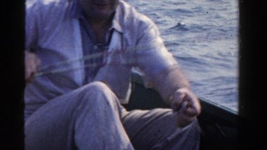 1958: Lively Older Gentleman Catching Fish on Boat During Bright Sunny Day