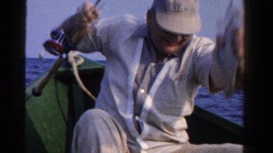 1958: man in fishing boat with recent catch MINNESOTA