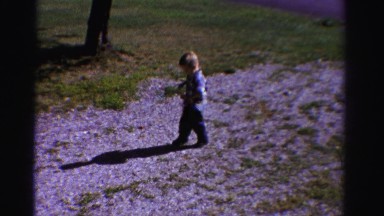 1958: boy walking gravel driveway to classic blue boat style car. MINNESOTA