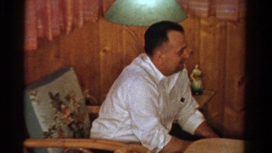 1958: man in chair leans in and smiles then points to young girl MINNESOTA