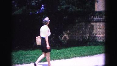 1964: woman walking next to building WILLIAMSBURG