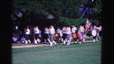 1964: band marches by with union flag. WILLIAMSBURG