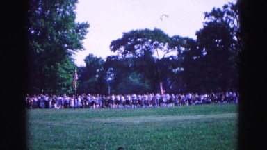 1964: members of school marching band pass observers at patriotic event