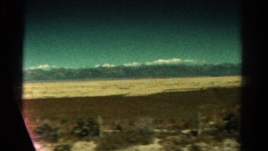 1967: journey through barren land fringed by large mountain range COLORADO