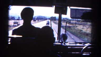 1967: bus driver silhouette view looking forward towards travel destination