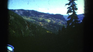 1967: beautiful blue sky above beautiful rugged mountain peak as seen pine trees
