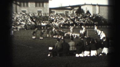 1946: high school football players lineup shifting during game view from stadium