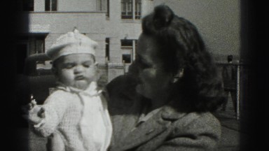 1946: mommy cuddling her baby with the smile on street side. HARRISBURG