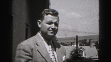 1946: dapper confident middle aged caucasian groom before wedding grey suit