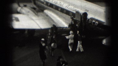 1946: distinguished travelers disembark from flight on propeller airplane
