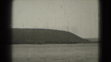 1946: panoramic view of lake with mountains and trees on the horizon