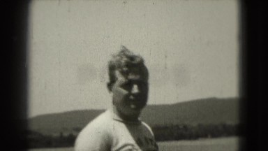 1946: Middle Aged Man in Penn State Sweatshirt Poses on Dock
