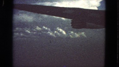 1963: Wing of an Airplane View from Passenger Window Seat Flying Over Clouds