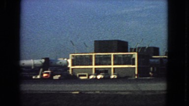 1963: view of large airport with many vehicles and huge airliners ready to load