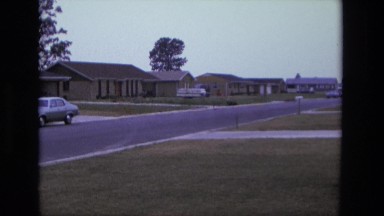 1975: Person Wearing Red Biking Through Neighborhood California