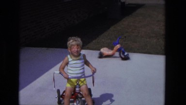 1975: Toddler Riding Cycle in California Backyard