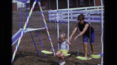 1975: woman pushing child on swing set outdoor CALIFORNIA
