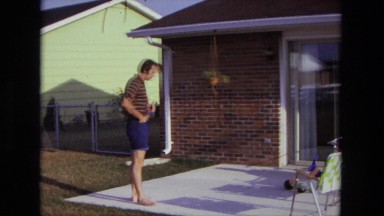 1975: man summertime backyard porch area lighting up cigarette CALIFORNIA