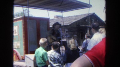 1962: man plays guitar to group of people at festival SAN PEDRO, CALIFORNIA