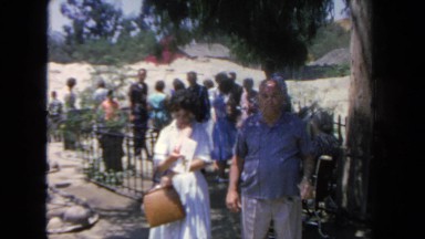 1962: woman is putting letters in her handbag as she and her husband stand in