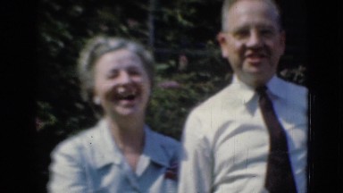 1947: group of people with tow women and one man standing together and laughing