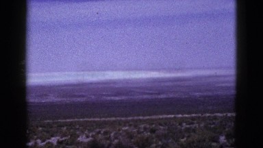 1953: panoramic view of highway in the middle of desert with car