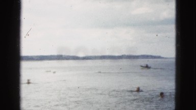 1953: people frolic in the ocean's waves as boat passes by CALIFORNIA