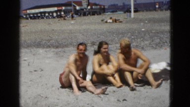 1953: two men and woman sitting on the beach and talking CALIFORNIA