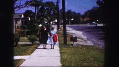 1960: Daughter Walking Elderly Grandmother Down Sidewalk Street Florida