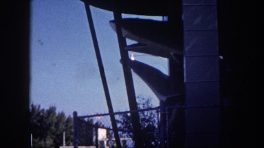 1960: shark animatronic building has couple of sharks floating above the ground.