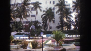 1960: outdoor of resort with fountain and chairs with palm trees FLORIDA
