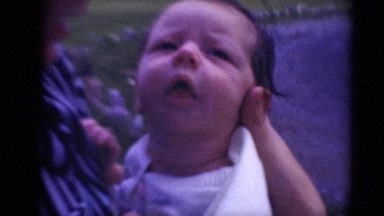 1947: mother holding newborn on chilly windy day holds him close protectively