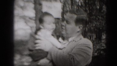 1947: loving father holding baby son waving hands cutely MIDDLETOWN