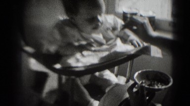 1947: young baby being fed by his mother in high chair next to window MIDDLETOWN