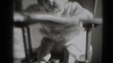 1947: baby at lunch time smacking his lips and mother attending to him