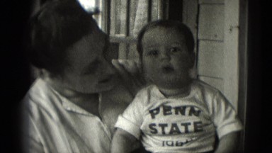 1947: baby in penn state t-shirt smiles and happily waves at the camera