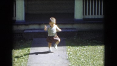 1947: child taking early steps in front of home while holding stick MIDDLETOWN