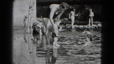 1947: woman dipping little boy in pond MIDDLETOWN