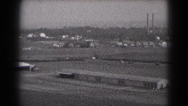 1947: airplane lands safely on an airstrip near an industrial area